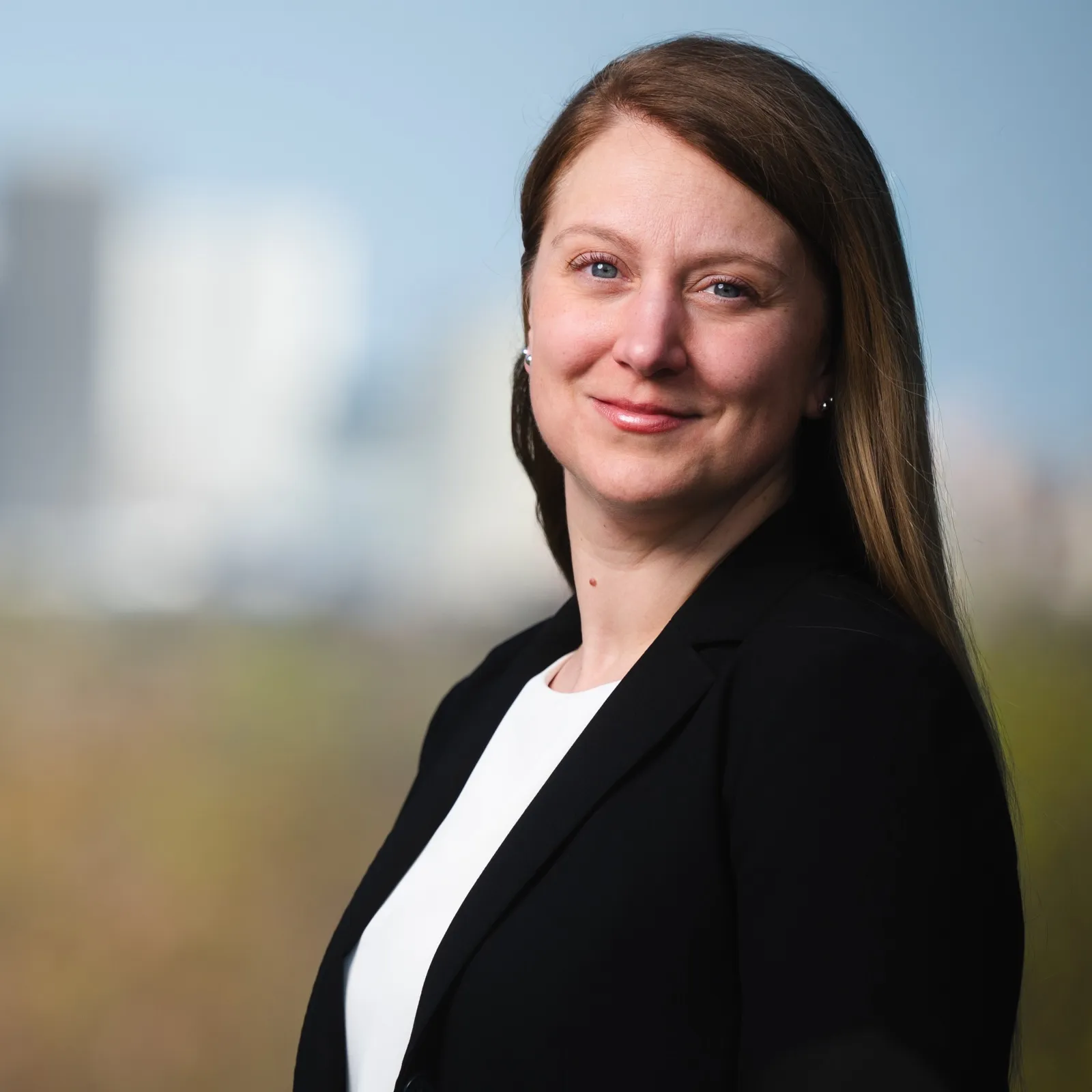 Alissa Brennan smiling in front of the Rochester, NY skyline