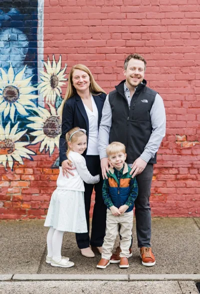 Alissa Brennan with her family in front of a sunflower mural in Rochester